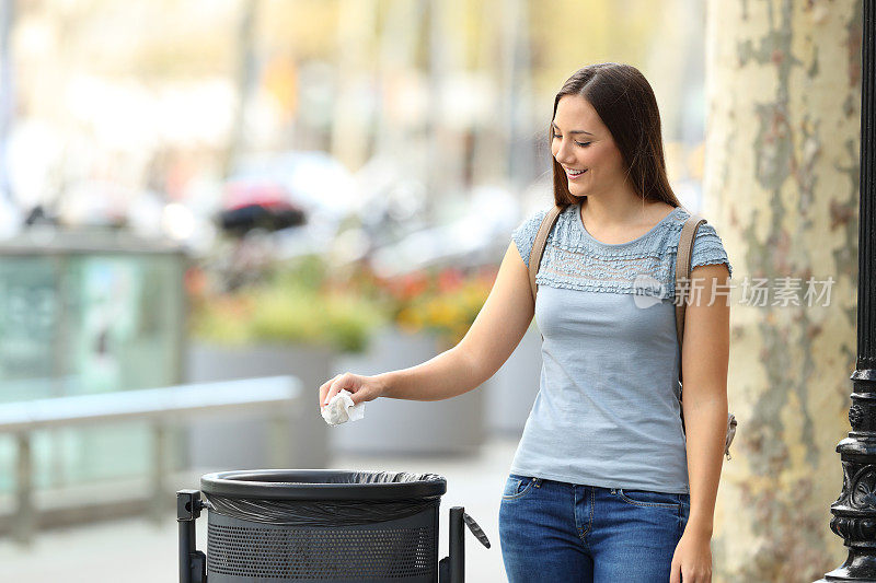 市民妇女把纸扔进垃圾桶