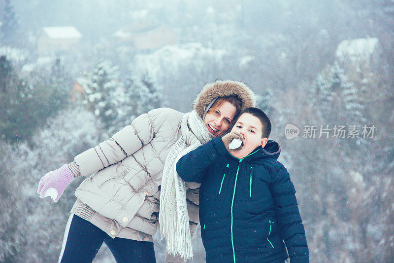 妈妈和儿子在雪地上玩得很开心