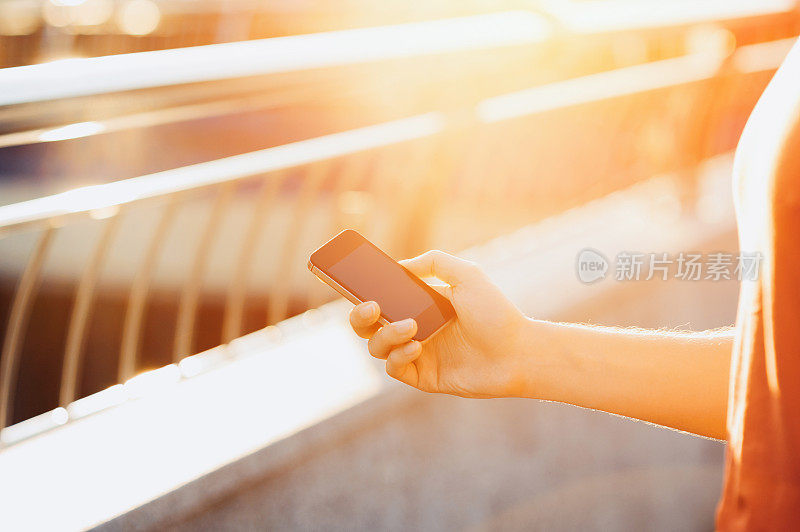 近距离男子使用手机智能手机软焦点在日落背景