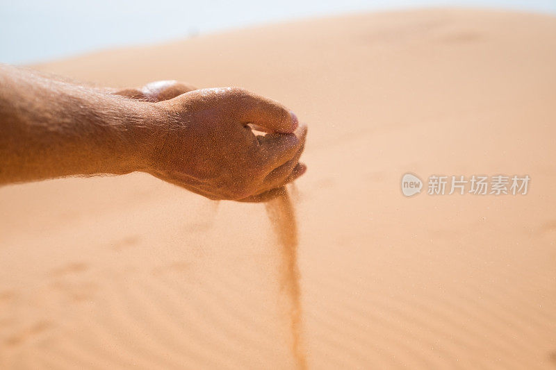手在沙漠中落下的沙子。