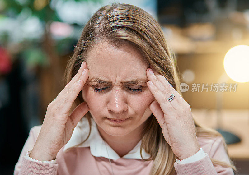 女职员皱眉，手对着头，闭着眼睛