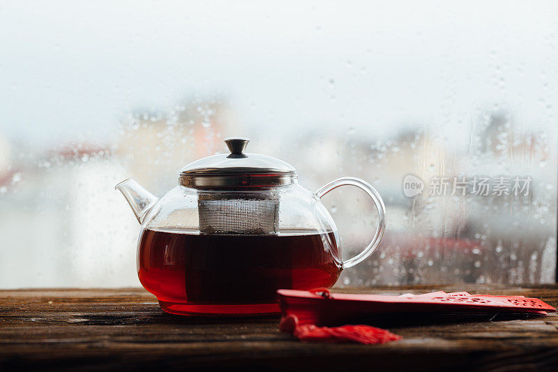 茶和手扇子的背景是一个下雨的城镇