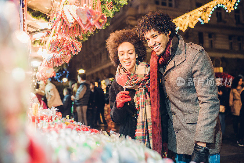 微笑的年轻夫妇购买糖果和圣诞礼物