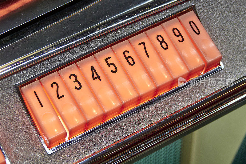 旧点唱机的一部分:橙色的数字选择按钮
