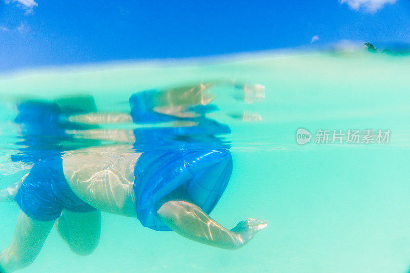 水下摄影一个孩子的水翼在海里游泳。