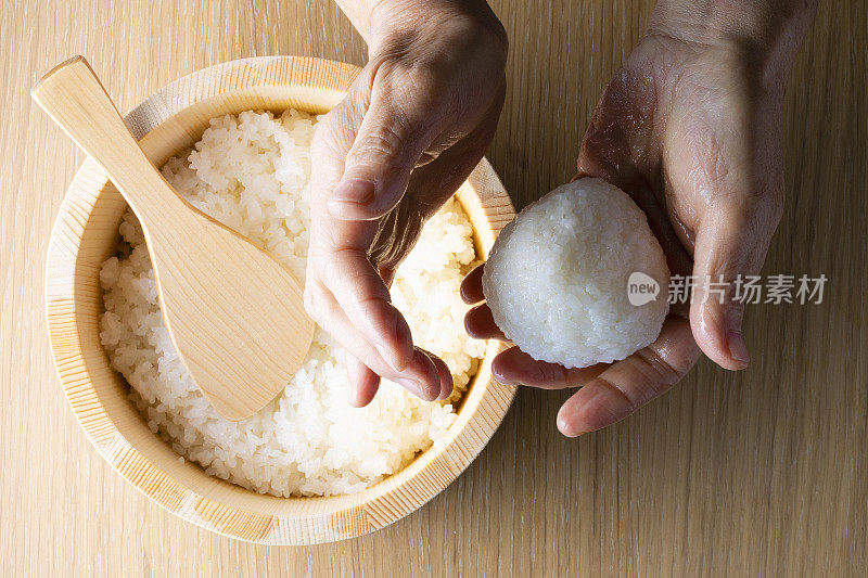 日本老妇人捧着饭团煮米饭