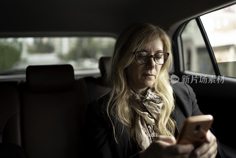 在出租车里用手机的女人