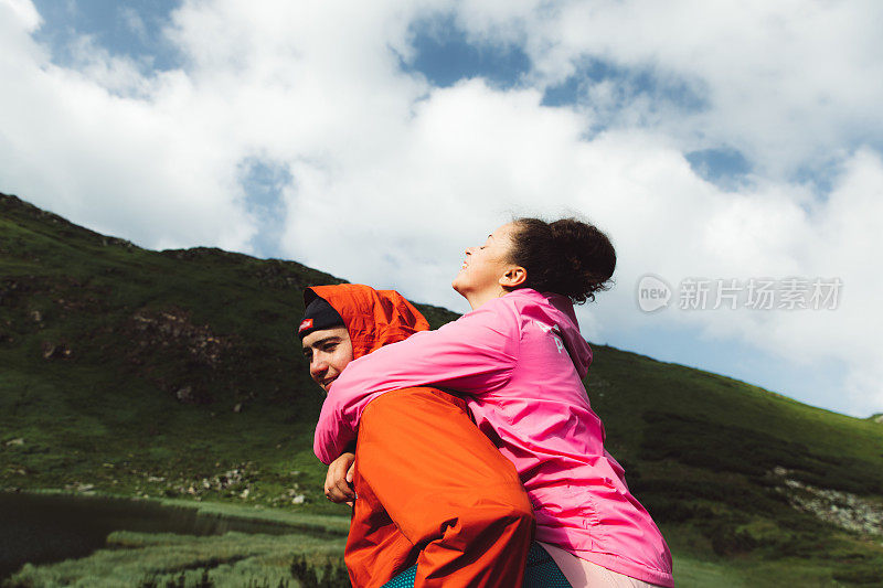 年轻夫妇在美丽的湖附近的山上玩耍