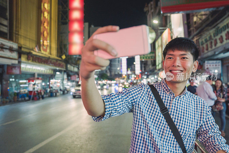 年轻的亚洲男人喜欢在泰国曼谷的中国城Yaowarat街旅游