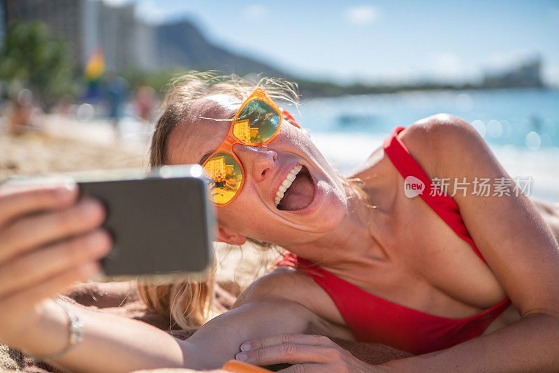 年轻女子在檀香山美丽的海滩自拍照片，夏威夷，美国