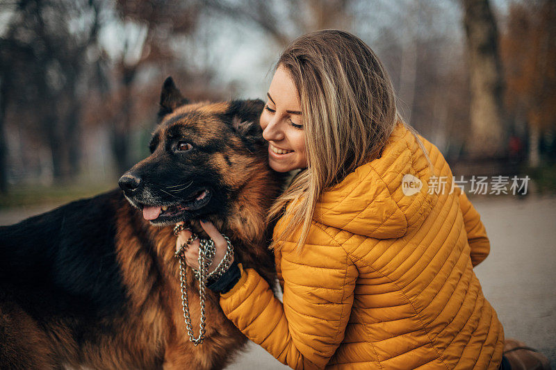 年轻女子和德国牧羊犬在公园里玩