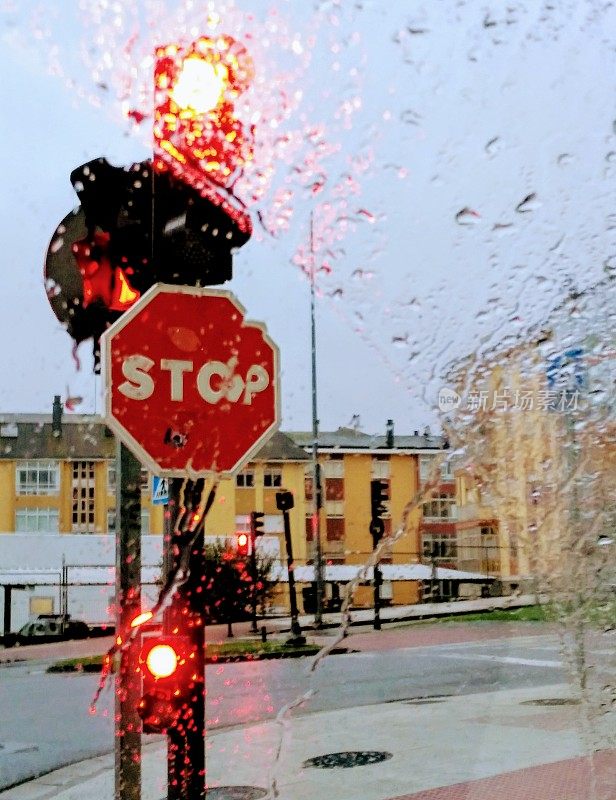 在雨天驾驶，停止标志，红灯。十字路口。