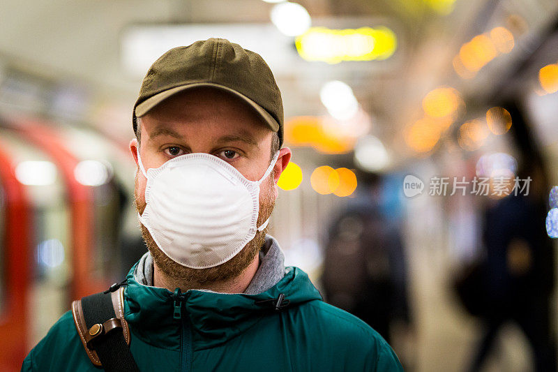 在城市地铁站戴着防护口罩的男子