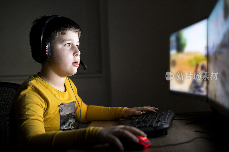 小男孩在家里玩电脑游戏