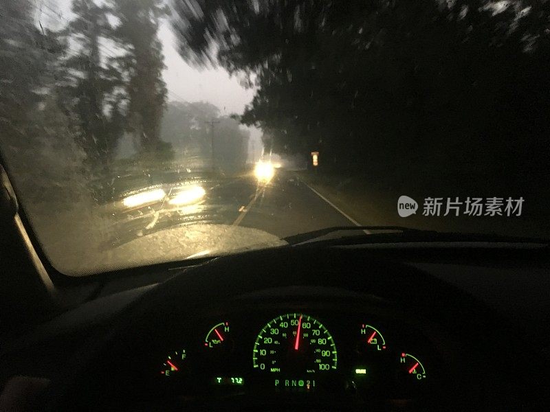 在黎明前的大雾中行驶在乡村道路上，被迎面驶来的车辆的前灯弄瞎了眼睛