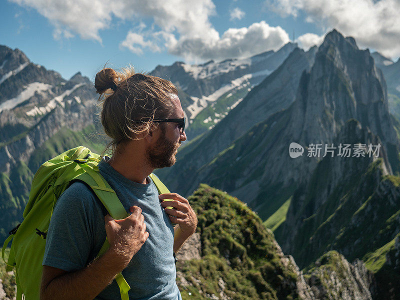 一名男子在瑞士徒步旅行，然后停下来看风景