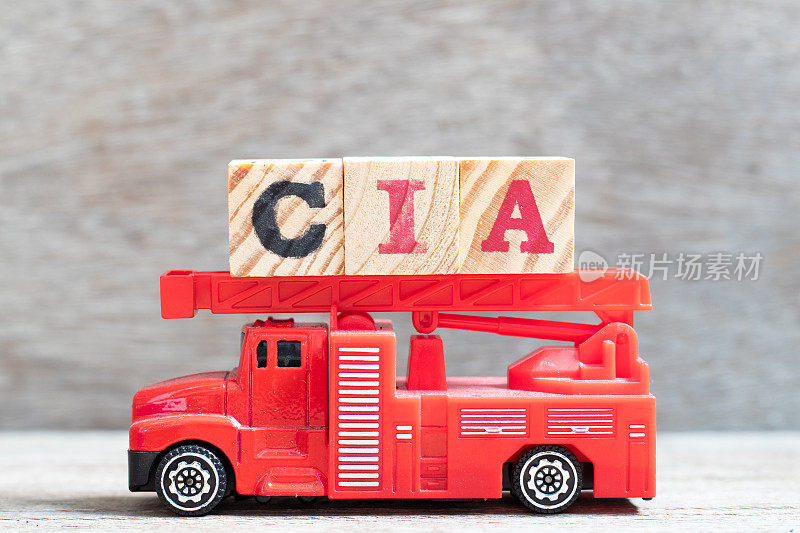 红色消防车持有字母块字CIA(注册内审员的缩写)木头背景