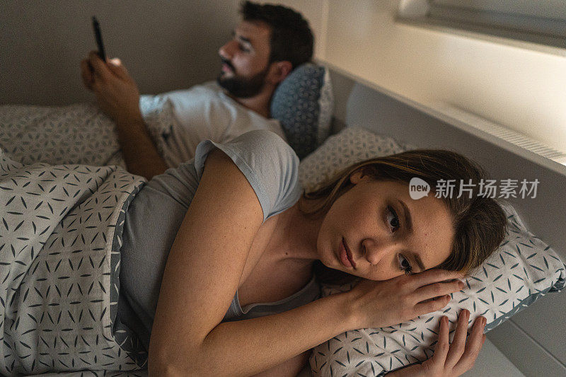 女人在她手机成瘾的丈夫身边感到孤独