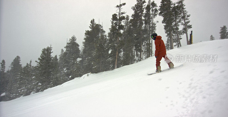在科罗拉多州博尔德附近的埃尔多拉滑雪度假村，一个穿着全套冬季装备的滑雪板滑下滑雪道