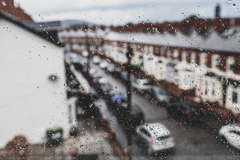 雨点打在窗户上，望向街边的房屋