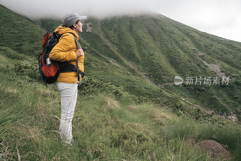 回归自然。独自在山里徒步旅行的女人。2019冠状病毒病大流行后阳光明媚的户外享受。