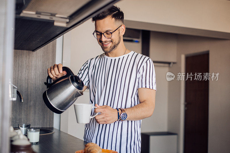 一个快乐的男人正在准备咖啡和早餐