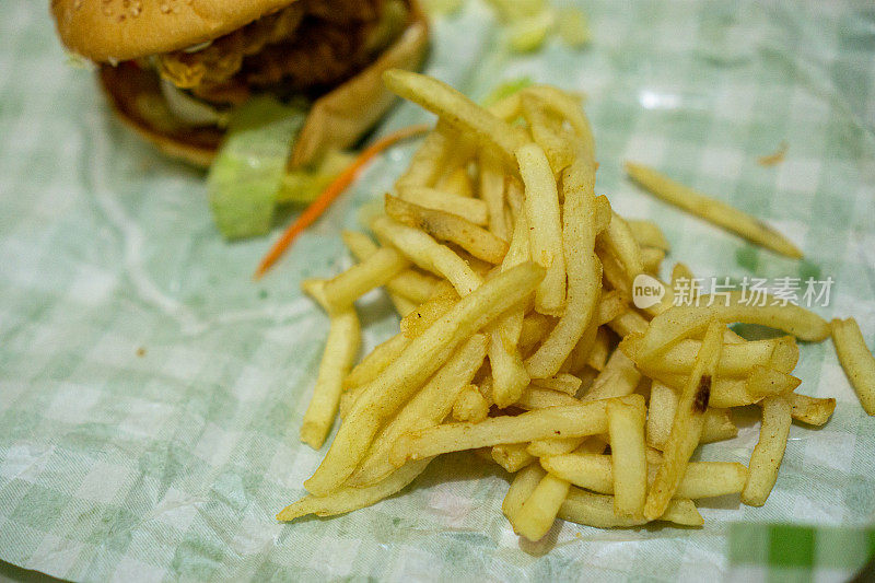 鸡肉汉堡和薯条放在包装纸上