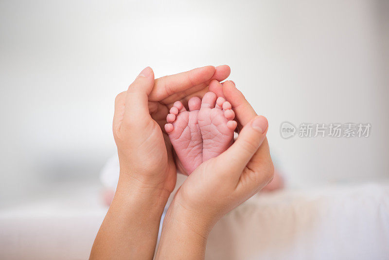 一个新生儿的脚在父母的手中