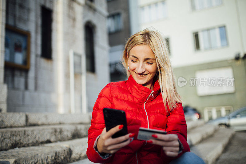 年轻的白人女人在用她的智能手机