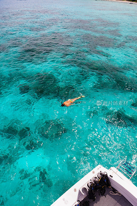 女人浮潜旁边的潜水船在维尔京群岛