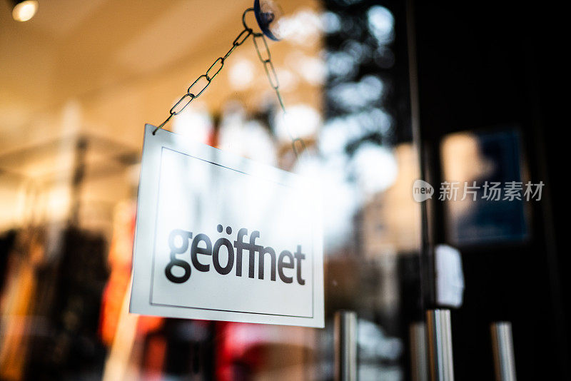 打开的标志(geöffnet)透过商店的玻璃门看到