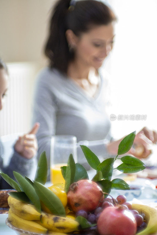 年轻女子和她的女儿在周末吃早餐