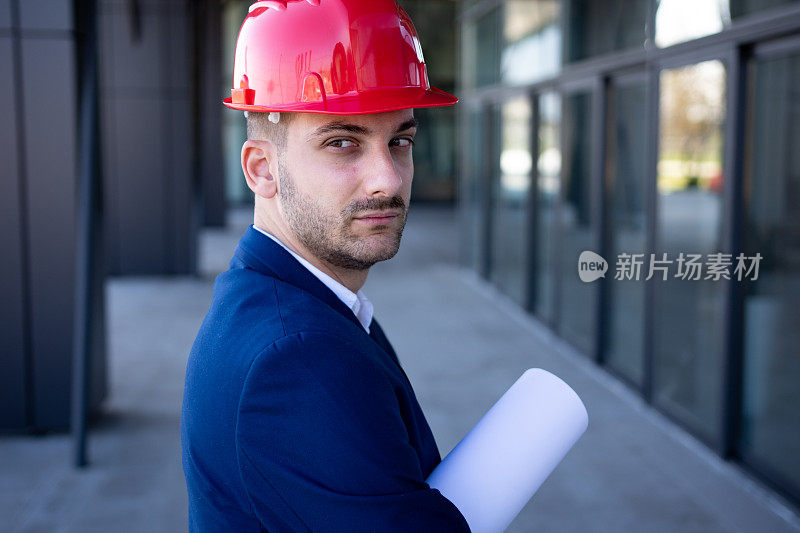 年轻的女建筑师拿着蓝图