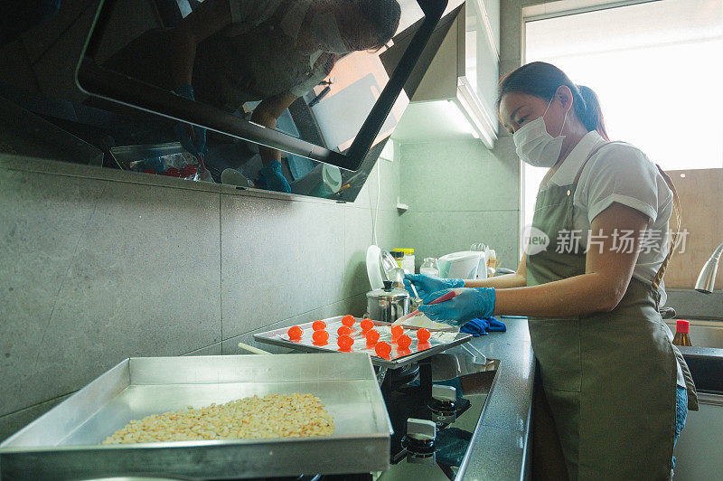 一位亚洲华人妇女在家里揉着食谱中的配料