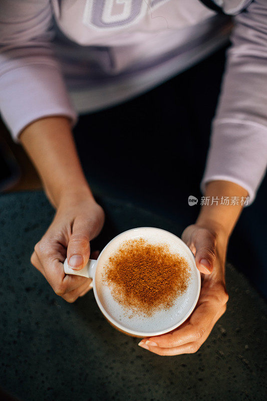 拿着一杯印度茶拿铁的女人