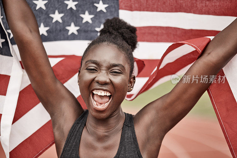 一名年轻的女运动员拿着一面旗子跑步庆祝胜利