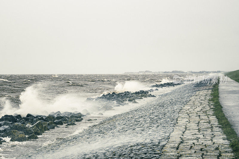 在冬季风暴中，海浪袭击了堤坝