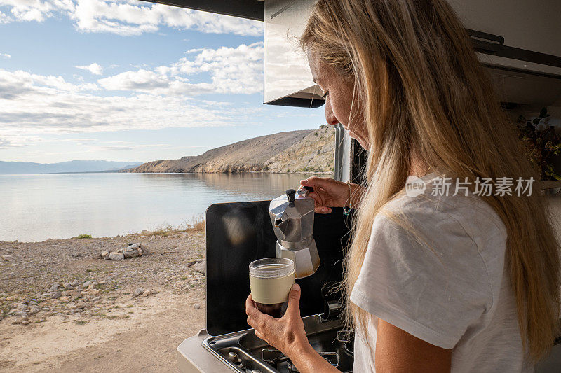 在车里端咖啡的女人，海滩风景