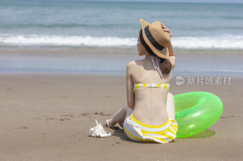 年轻女人坐在沙滩上
