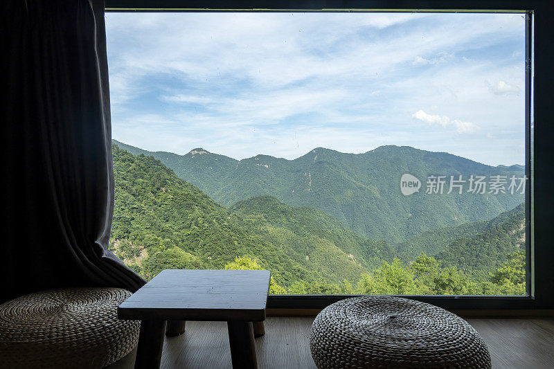 坐在落地窗前，看着窗外的山景