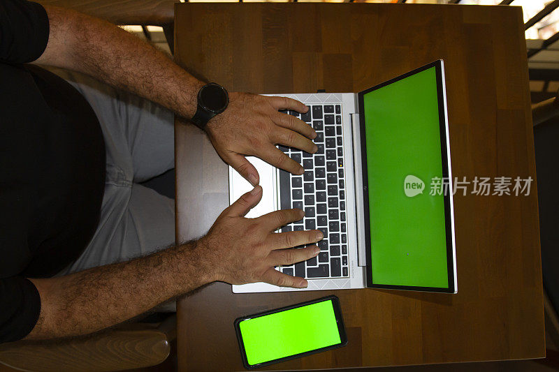 商务人士正在办公，笔记本电脑绿屏，手机绿屏在桌子上横着拍照