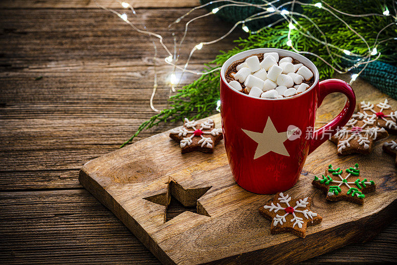 红色热巧克力杯与棉花糖和饼干在圣诞餐桌上