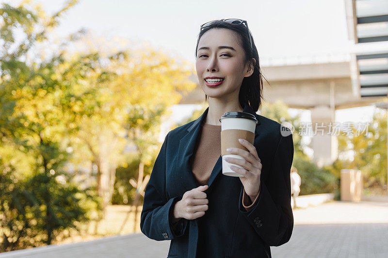 成功的女经理走在城市的街道上。