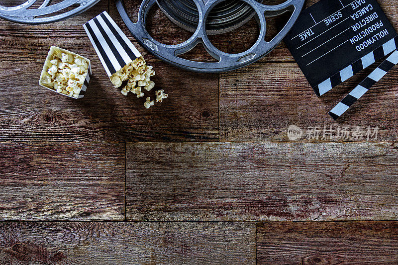 黑白条纹袋爆米花隔板和电影卷轴上的复古木材背景