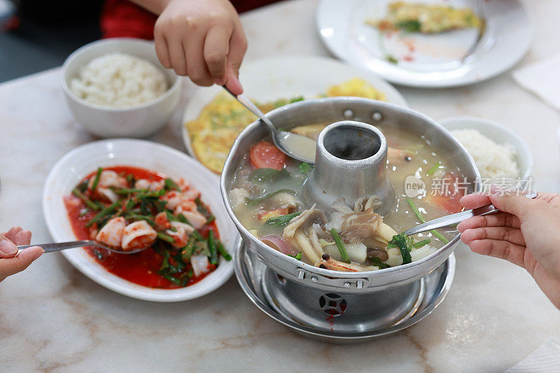 游客享用正宗的泰国冬阴功美食配上香喷喷的米饭的特写