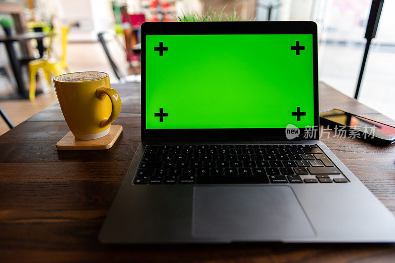 绿色背景和黄色咖啡杯的电脑