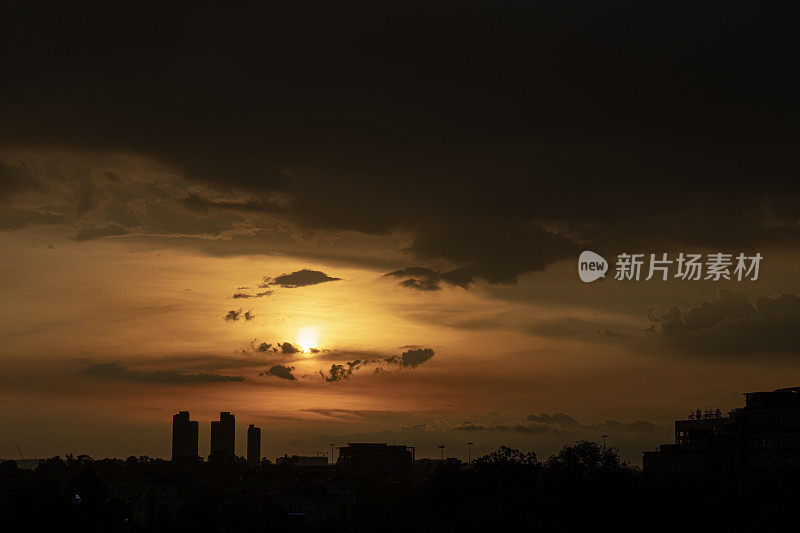 夕阳下乌云密布的剪影城市