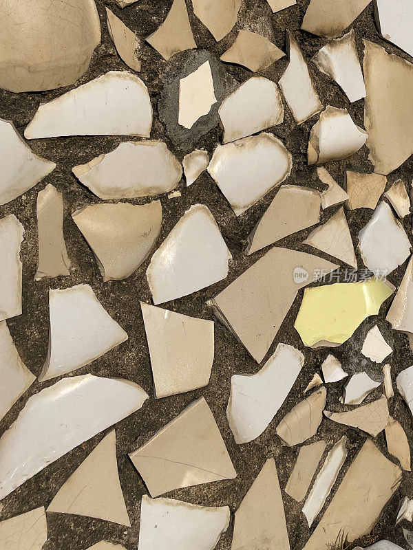 全画幅图像的陶器碎片马赛克墙，随机设计与棕色，米色和黄色的碎陶器，墙纸背景，重点在前景