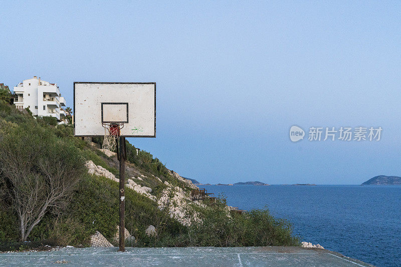 夕阳下的沙滩上孤零零的篮球场