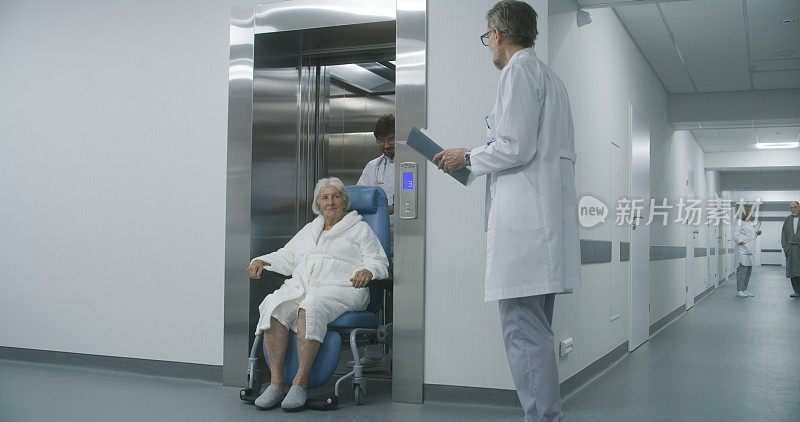 医生用轮椅把病人从电梯里抬出来